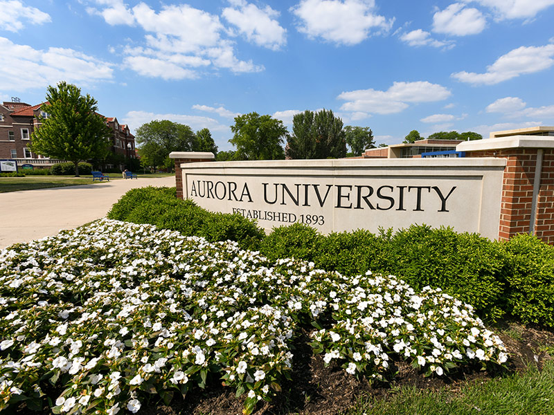 aurora university monument sign with white flower beds