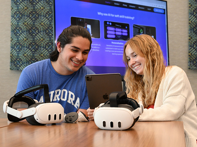 student learning to work VR gear with a staff member