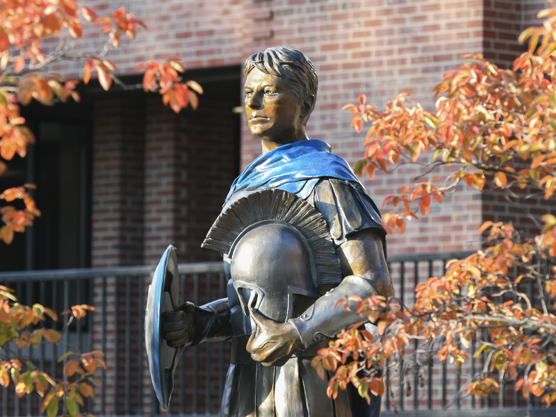 Spartan statue overlooks the quad in the fall