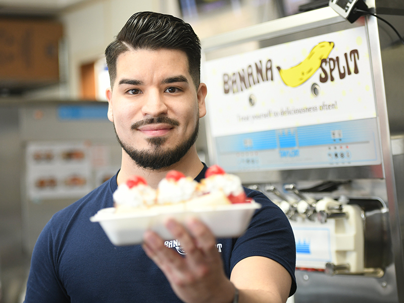 Daniel Cuevas holds a banana split sundae