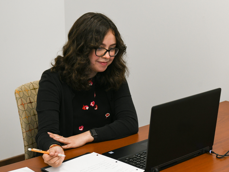 Student working on her resume in front of a laptop.