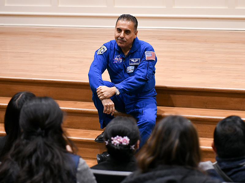 José M. Hernández sits on the steps of Tapper Recital Hall stage to talk to audience of AU students