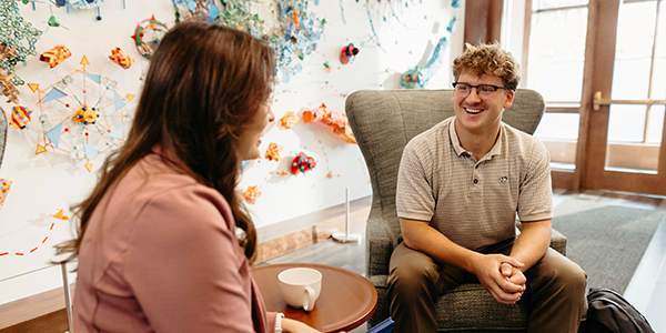 Male student talking with an AU staff member.