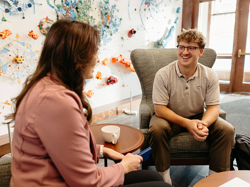 Male student talking with AU staff member.