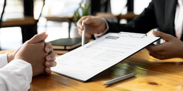 Person showing a document to another person.
