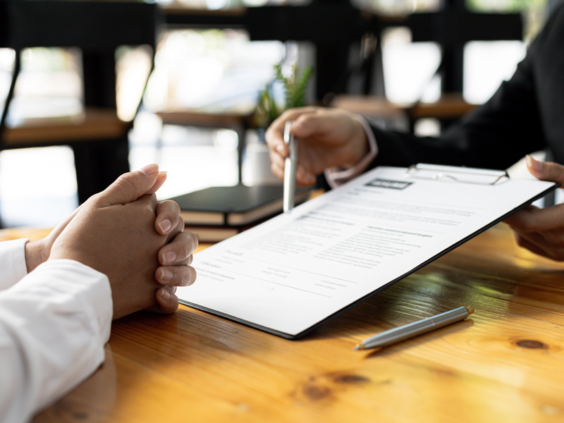 Person showing a document to another person.