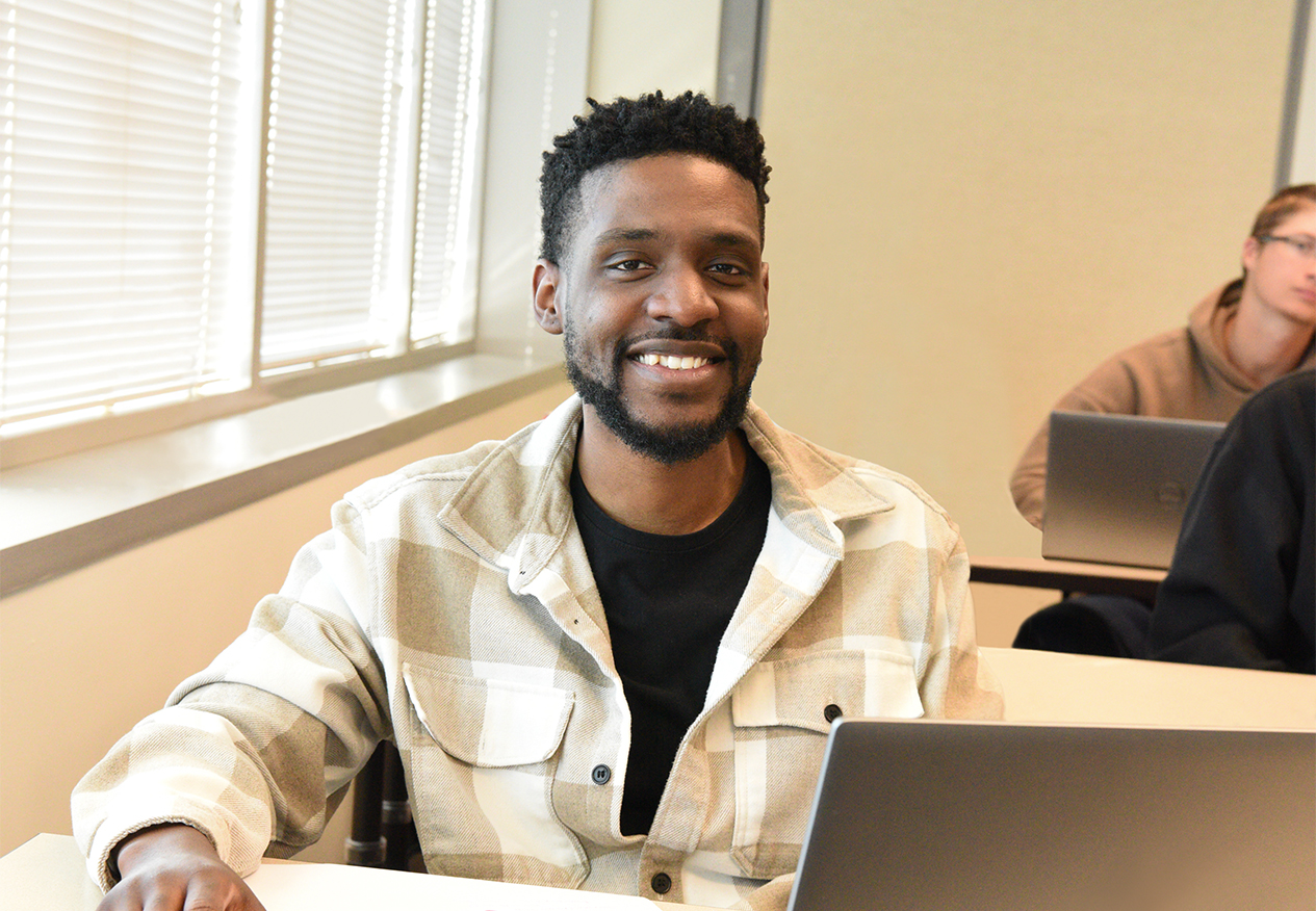 graduate student smiling in a classroom