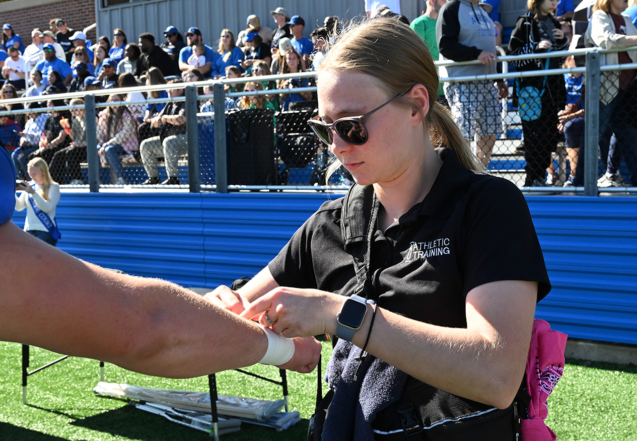 athletic training student on the sidelines of a football game