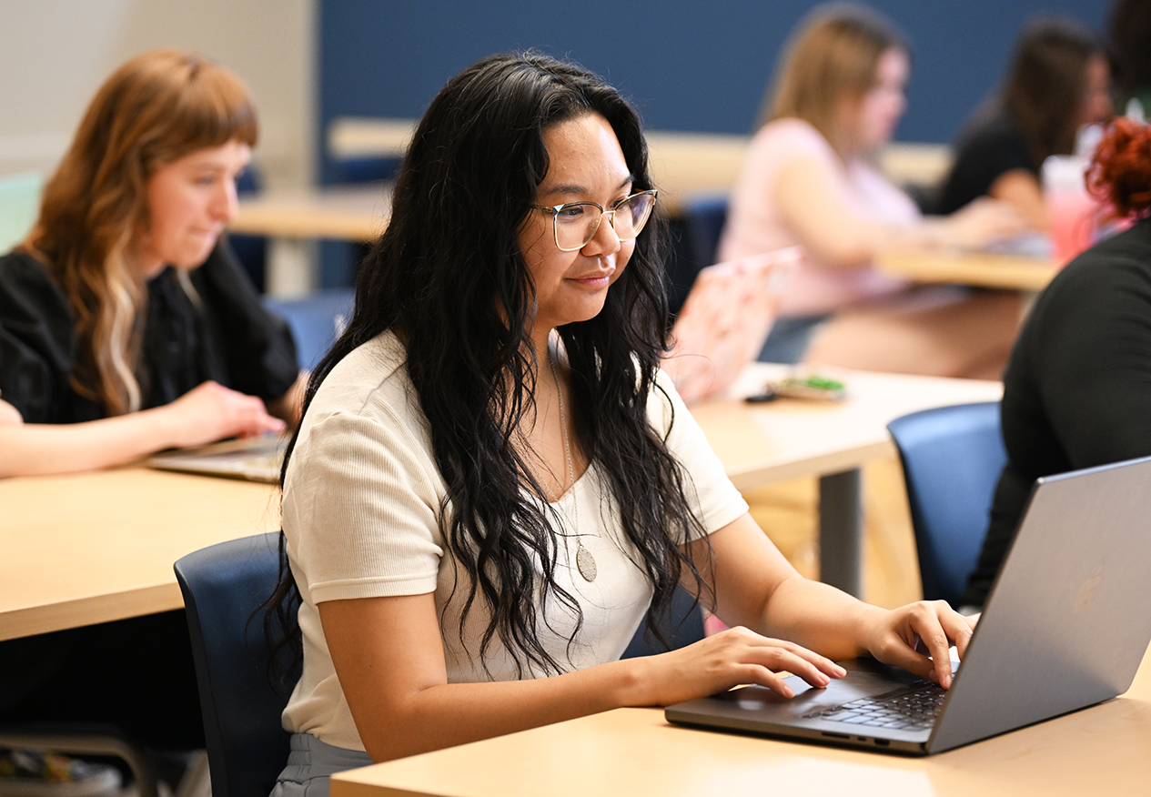 student taking notes on a laptop during class