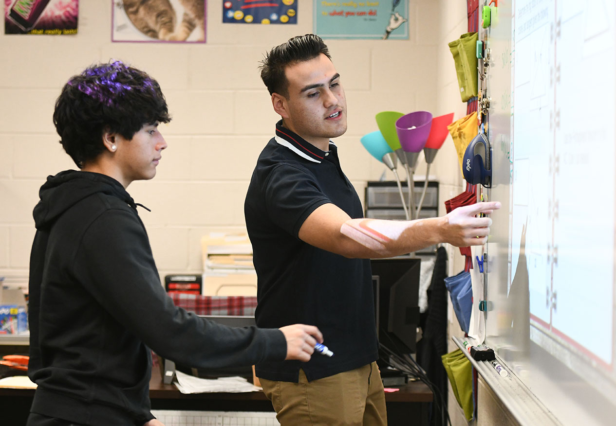 Student teacher teaching in classroom.